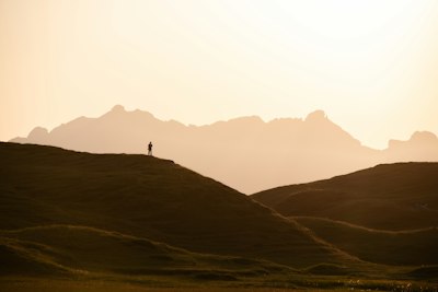 A lone walker on a hill at dusk