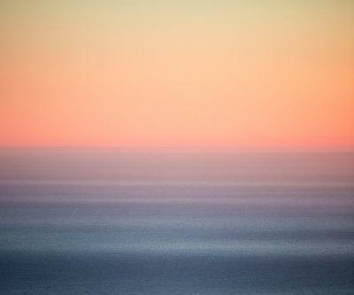 Soft pink sky over a still sea